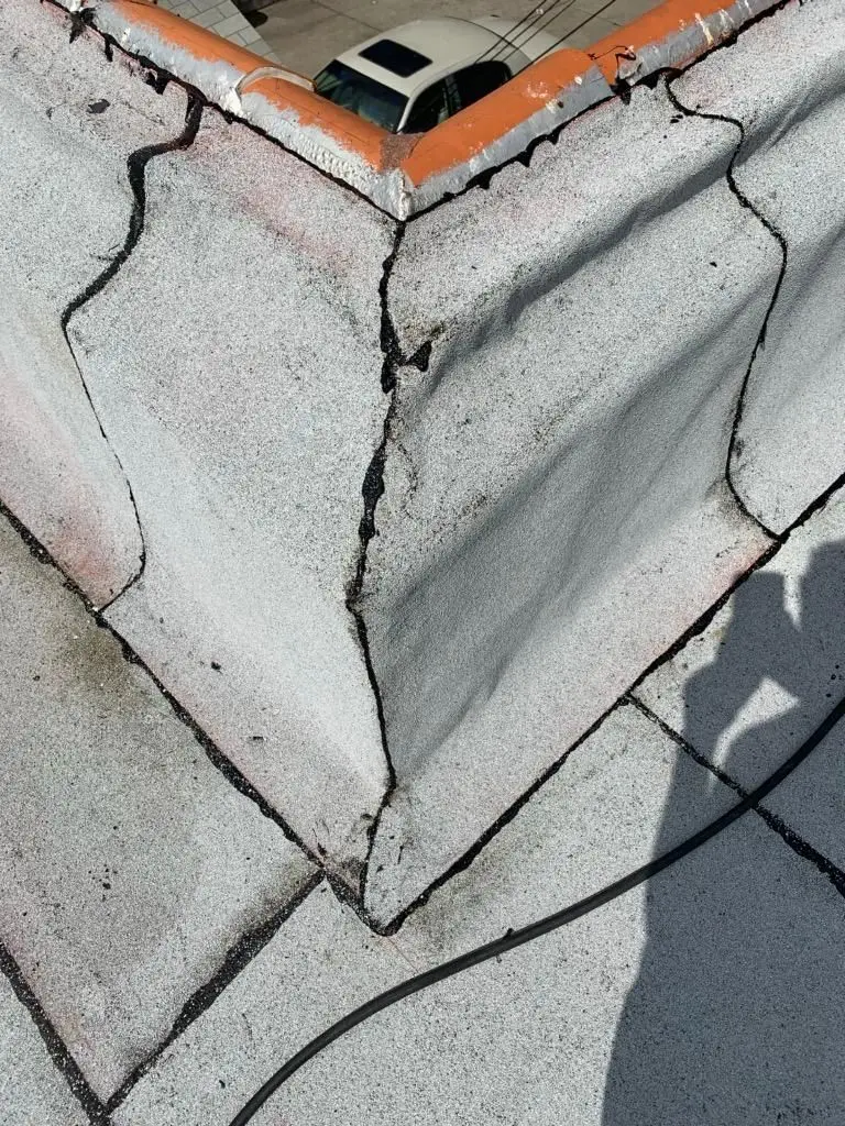 Close-up of a flashed corner where a flat roof meets the parapet