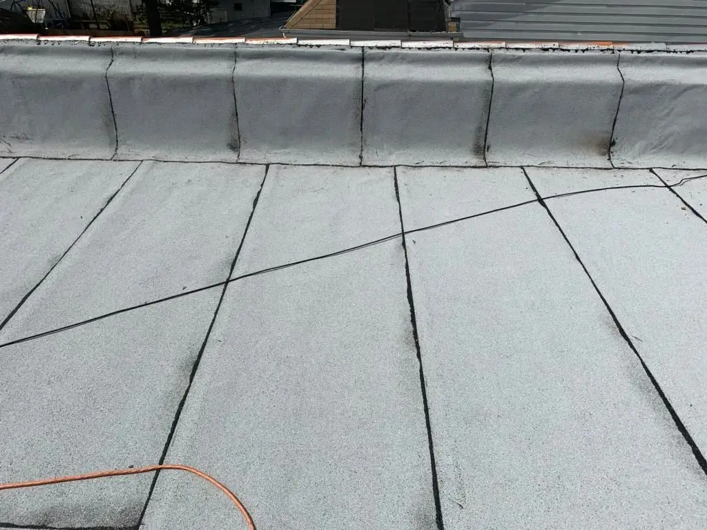 New flat roof with sealed seams and a coated parapet wall