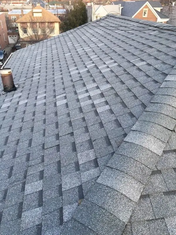 New grey architectural shingles along a roof ridge
